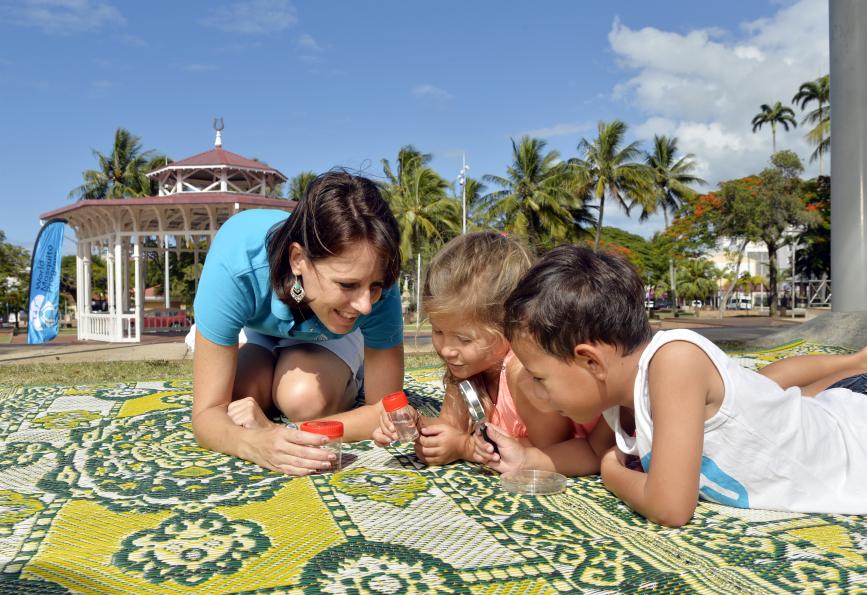 A WMP staff member helps local children get a closer look at mosquito larvae. Photo: Eric Aubry