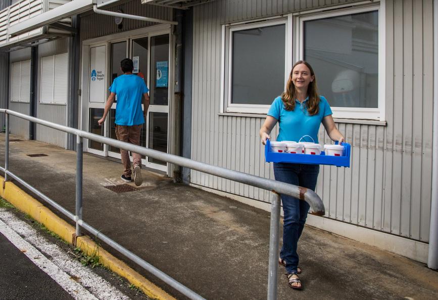 Nadege Rossi carrying mosquito release containers